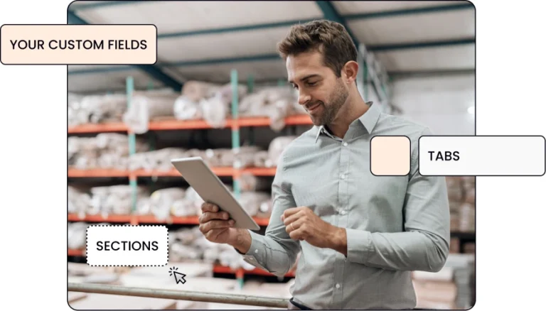 a man looking at his tablet while standing in a warehouse