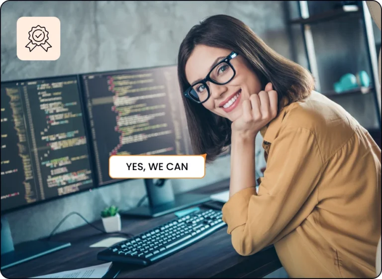 a woman sitting at the desk, working on the computer and smiling