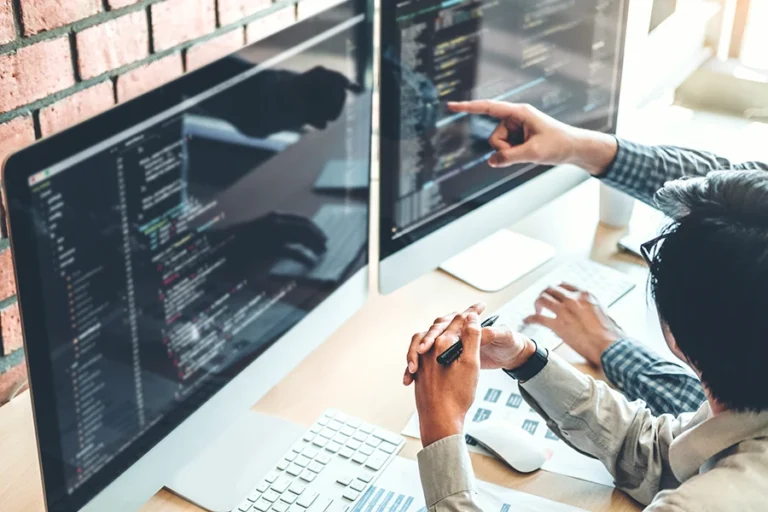 two people looking at the code on their screens